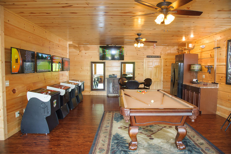 The pool table and arcade cabinets in one of our cabin rentals